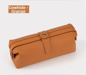 Detail of genuine cowhide makeup bag with retro metal clasp and textured orange leather