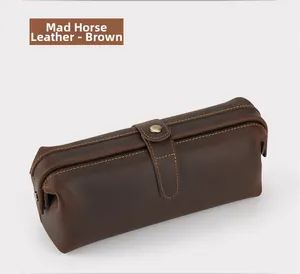 Detail of crazy horse leather wash bag in brown with stitching and metal snap closure
