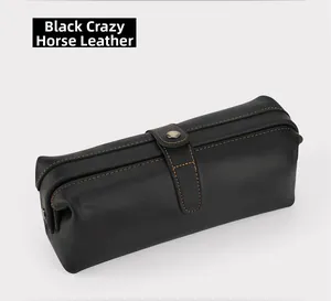 Detail of black crazy horse leather pouch with vintage stitching and metal buckle