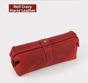 Detail of red crazy horse leather toiletry bag with vintage buckle and hand stitching