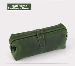 Macro detail of dark green Crazy Horse leather wash bag with vintage metal strap buckle