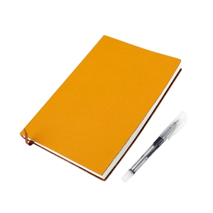 Détail d'un carnet A5 en cuir orange avec ruban marque-page et stylo à encre gel noir