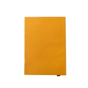 Détail du carnet A5 en cuir jaune moutarde avec texture à grain de galets minimaliste