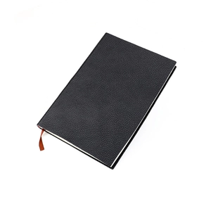 Gros plan du carnet A5 en cuir noir texturé avec un ruban marque-page en soie marron élégant