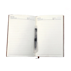 Carnet A5 en cuir véritable avec pages lignées et stylo sur un fond blanc propre