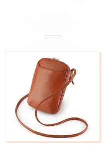 Close-up of caramel brown genuine leather phone bag with litchi grain texture
