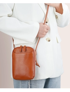 Detail of brown litchi pattern leather mini crossbody phone bag with double zip closure