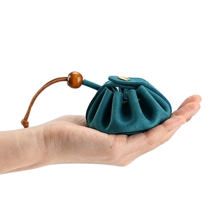 Handheld dark green vintage leather coin pouch with drawstring and gold metal clasp closure