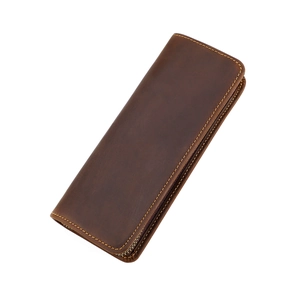Vista detallada de estuche de cuero marrón vintage con cremallera metálica y costuras finas