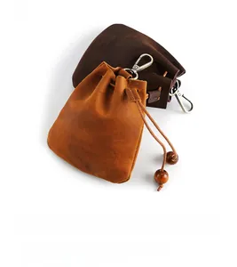 Détail de pochettes à clés en cuir véritable faites main avec cordon et perles en bois