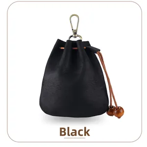 Détail d'une pochette en cuir noir avec crochet vintage et cordon à perles tressé