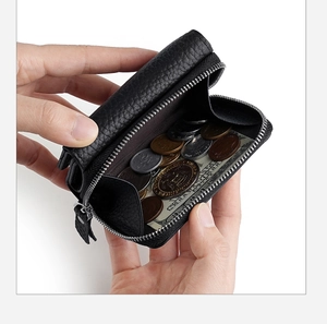 Macro view of black litchi grain leather wallet showing compact interior for coins