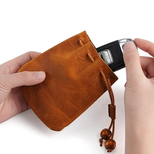 Petit sac à monnaie fait main en cuir brun avec cordon et perles en bois naturel