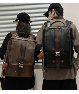 Detail of vintage PU leather backpacks with metal buckles and plush bear charm