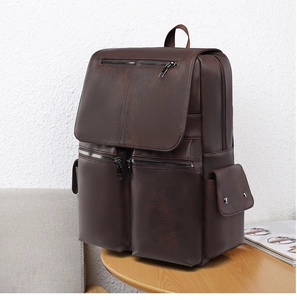 Detailed view of deep brown vintage PU leather backpack with side pockets and smooth texture