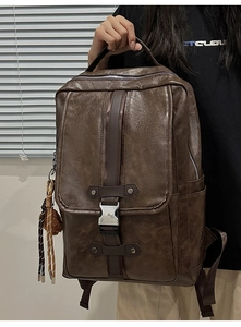 Detailed view of vintage dark brown PU leather backpack with metallic buckle and tassel