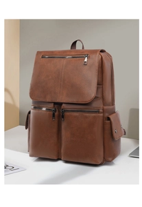 Macro shot of brown faux leather texture and metal zipper detail on a business backpack