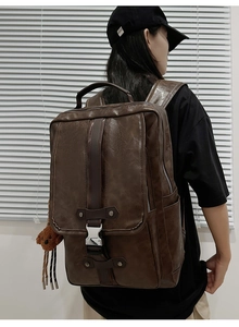 Detailed view of brown PU leather backpack with metal buckles and bear charm pendant