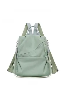 Detailed front view of green corduroy backpack with woven zipper pulls and metal hardware