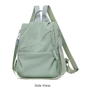 Side view of corduroy travel backpack in mint green with blue straps and pocket detail