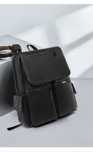 Detail of black textured leather laptop backpack with dual front zippers and flap closure