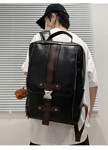 Detail of black PU leather business backpack with brown straps and silver metal buckle