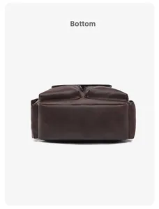 Detailed macro view showing the reinforced bottom of the brown textured leather backpack