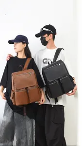 Close-up of textured faux leather backpacks in brown and black with zipper pockets
