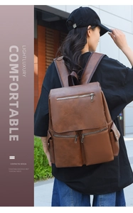 Detailed outdoor shot of the brown PU leather backpack with vintage zipper pockets