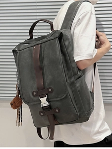 Detail view of vintage grey-green PU leather backpack with brown trim and bear charm