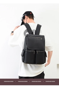 Rear view of man wearing a black leather backpack with lychee texture and multi-pockets