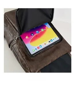 Detail of the front pocket storage capacity for a tablet in a brown PU leather backpack