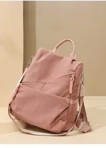 Detail of pink corduroy backpack featuring front zipper pocket and side pouch pockets