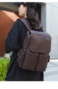 Detail view of coffee brown vintage faux leather backpack with side pockets and buckles