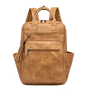 Detail of vintage brown PU leather backpack featuring tassel zippers and side pockets