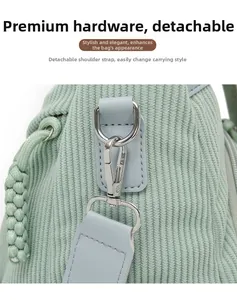 Close-up of mint green corduroy backpack with silver metal D-ring and lobster clasp