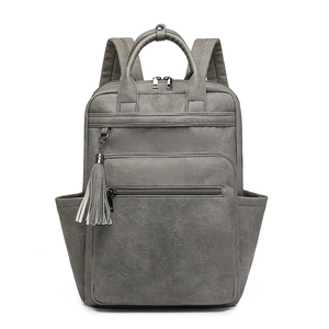 Detail of grey pebble leather backpack showing top handle and side tassel ornament