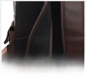 Close-up of wide breathable mesh shoulder straps on a brown leather business backpack