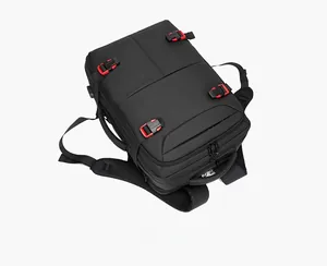 Detail of black travel backpack featuring red buckles and built-in USB charging port