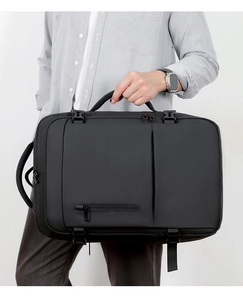 Detail of waterproof matte black business backpack showing side buckles and reinforced handles