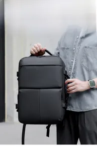 Men's large capacity business travel backpack worn by a model in an urban outdoor setting