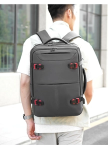 Back view of a grey business backpack on a man's shoulders with sleek red buckles