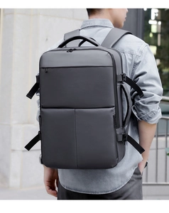 Outdoor shot of the men's grey travel backpack showing back padding and ergonomic straps