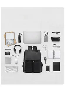 Flat lay of black leather laptop backpack with multiple gadgets showing storage capacity
