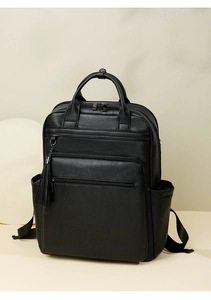 Detail of black pebbled PU leather backpack with tassel ornament and multiple zip pockets