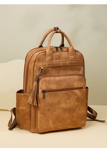 Detail view of large capacity faux leather backpack with stylish tassel in camel brown