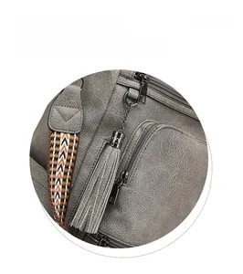 Detail of grey pebble leather backpack with metal tassel zipper and woven strap