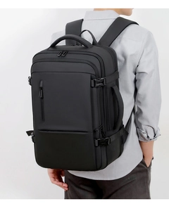 Side view of black expandable travel backpack showing reinforced buckles and side handle