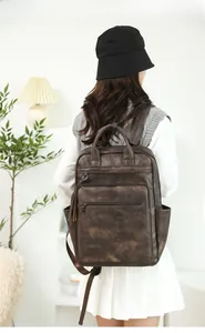 Deep brown vintage PU leather backpack with tassel detail and large capacity shown on model