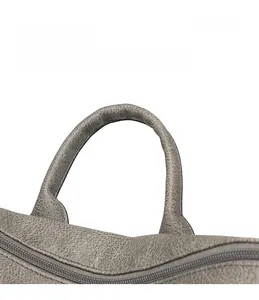 Detail display of a pebble grain PU leather backpack showing comfortable handle and zipper